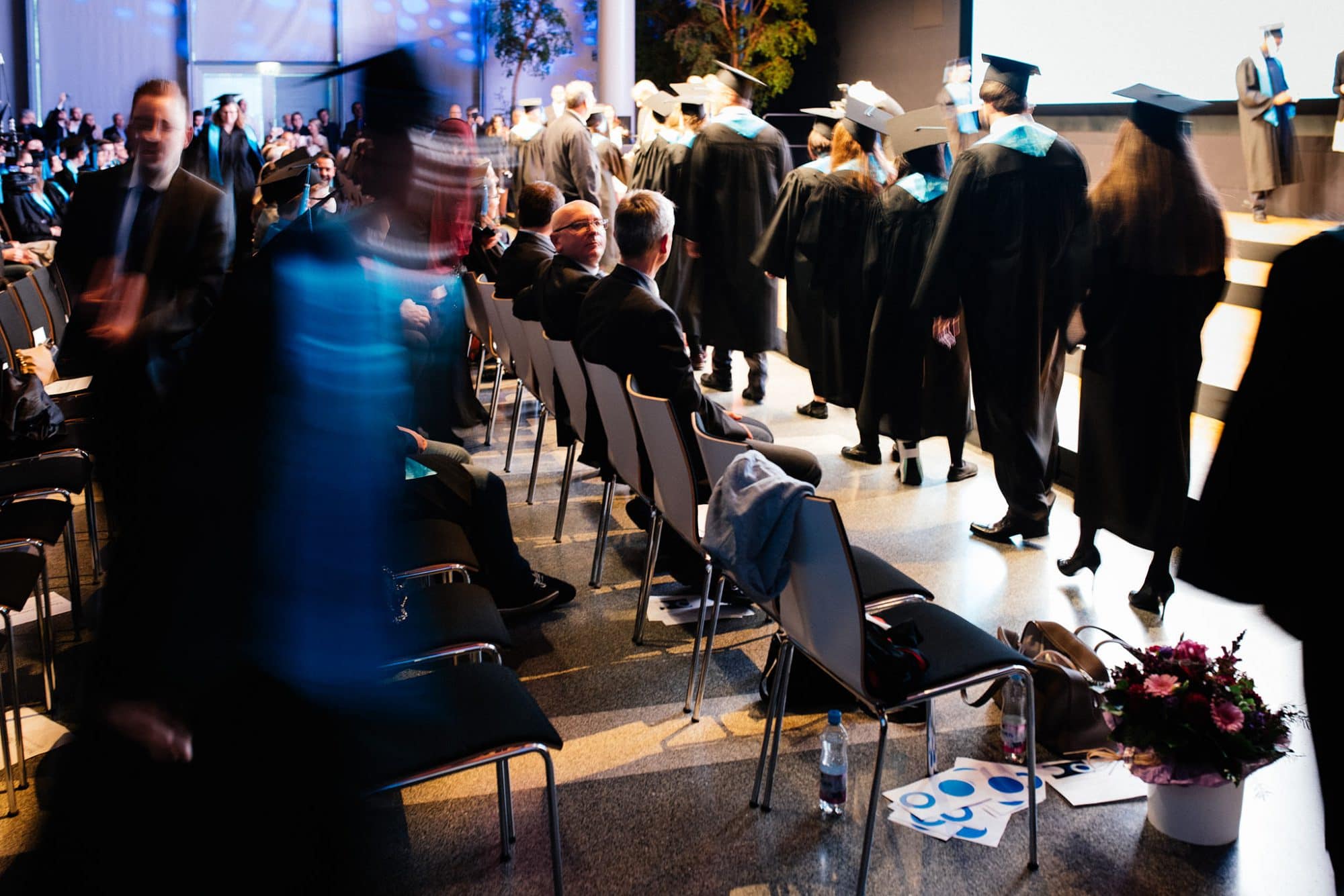 Die Absolventen warten darauf ihr Zeugnis zu bekommen.