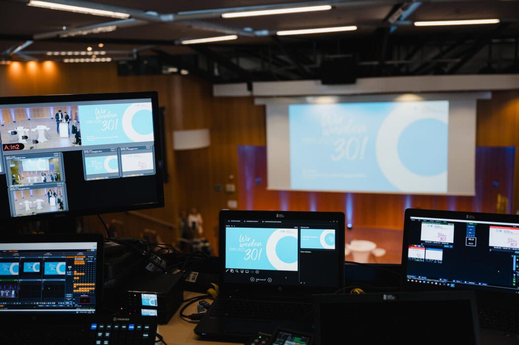 Festakt und Vielfalt: Das 30-jährige Jubiläum der Hochschule Bonn-Rhein-Sieg 5 Blick auf eine Konferenz- oder Veranstaltungsraum mit Technik und Projektionsfläche.