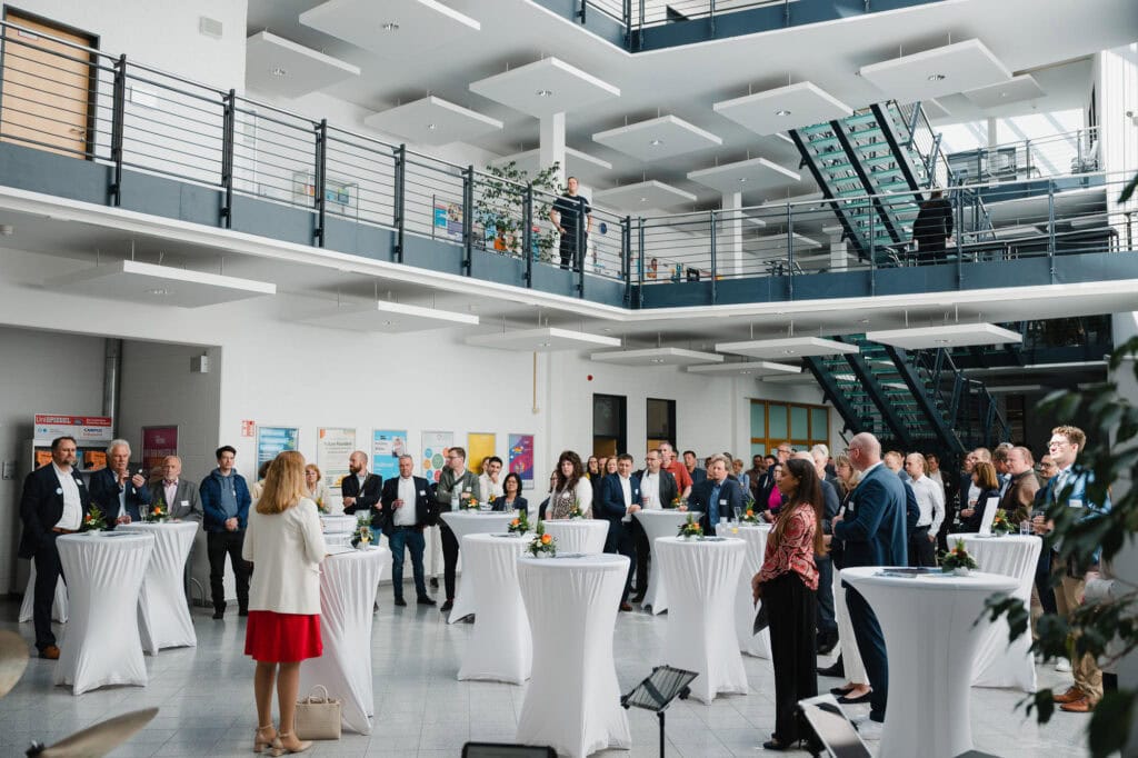 Festakt und Vielfalt: Das 30-jährige Jubiläum der Hochschule Bonn-Rhein-Sieg 18 Networking bei Jubiläumsfeier der Hochschule Bonn-Rhein-Sieg in modernem Gebäude.