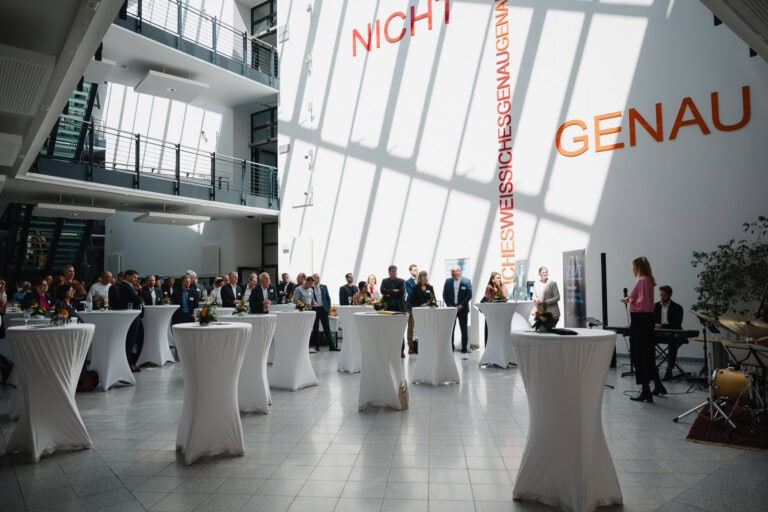 Festveranstaltung im modernen Hochschulgeb&auml;ude mit G&auml;sten und Rednern.