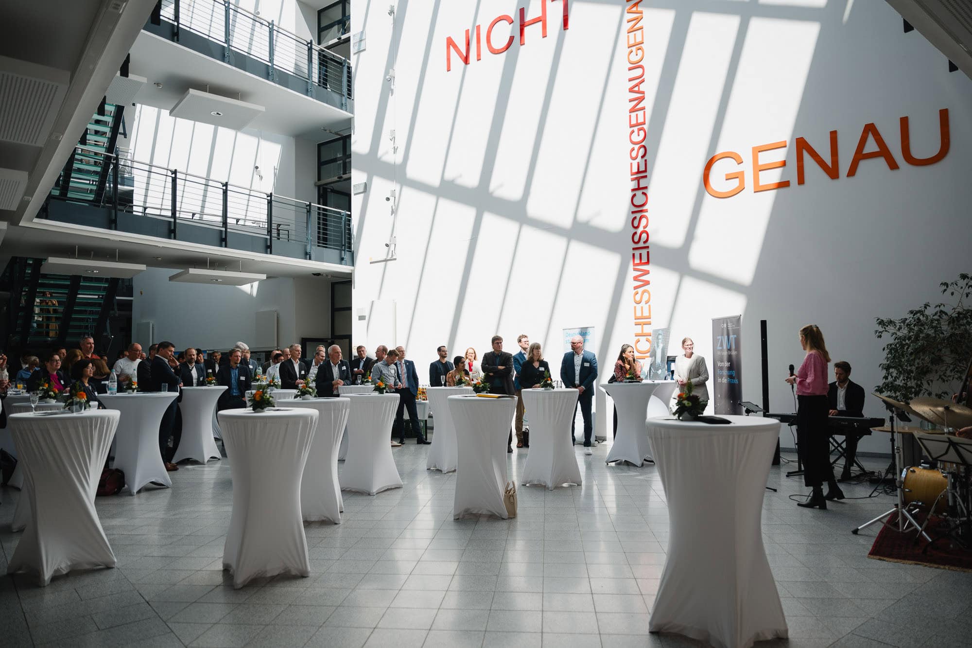 Festveranstaltung im modernen Hochschulgeb&auml;ude mit G&auml;sten und Rednern.