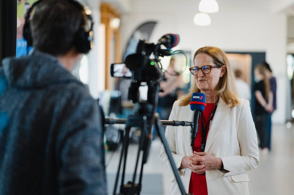 Festakt und Vielfalt: Das 30-jährige Jubiläum der Hochschule Bonn-Rhein-Sieg 29 Journalistin interviewt Frau bei Jubiläumsveranstaltung der Hochschule Bonn-Rhein-Sieg.