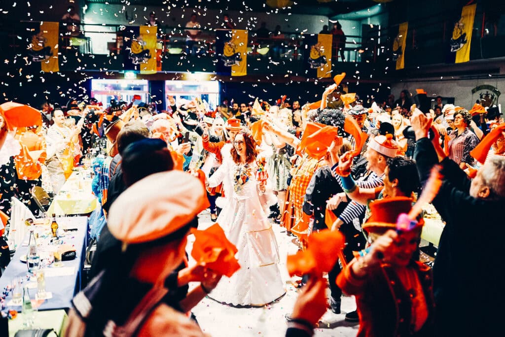 Karneval in Bonn mit tanzenden Menschen in bunten Kost&uuml;men.