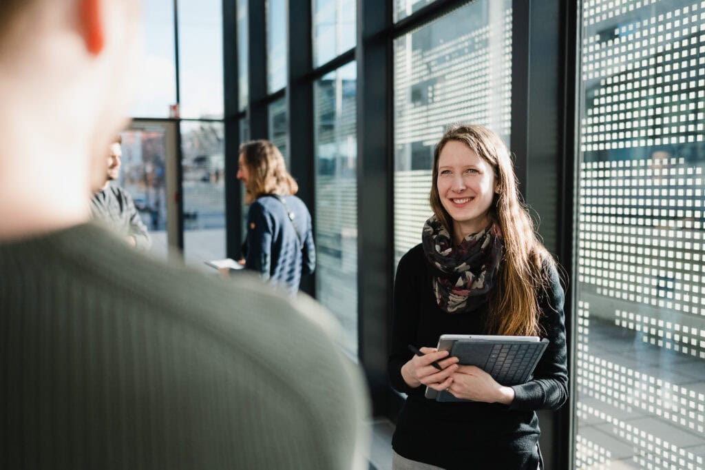 AI made in Germany: Ein zukunftsweisender Bildpool für die Konrad Zuse Schools (DAAD) 11 Moderne Businessfotografie in Köln mit lachender Frau im Gespräch.