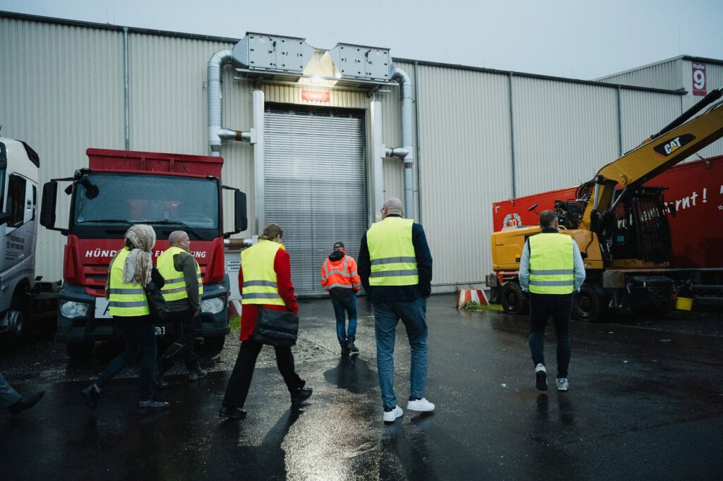 Besprechung bei Kreislaufwirtschafts-Workshop mit Industriefahrzeugen und Bauger&auml;ten.