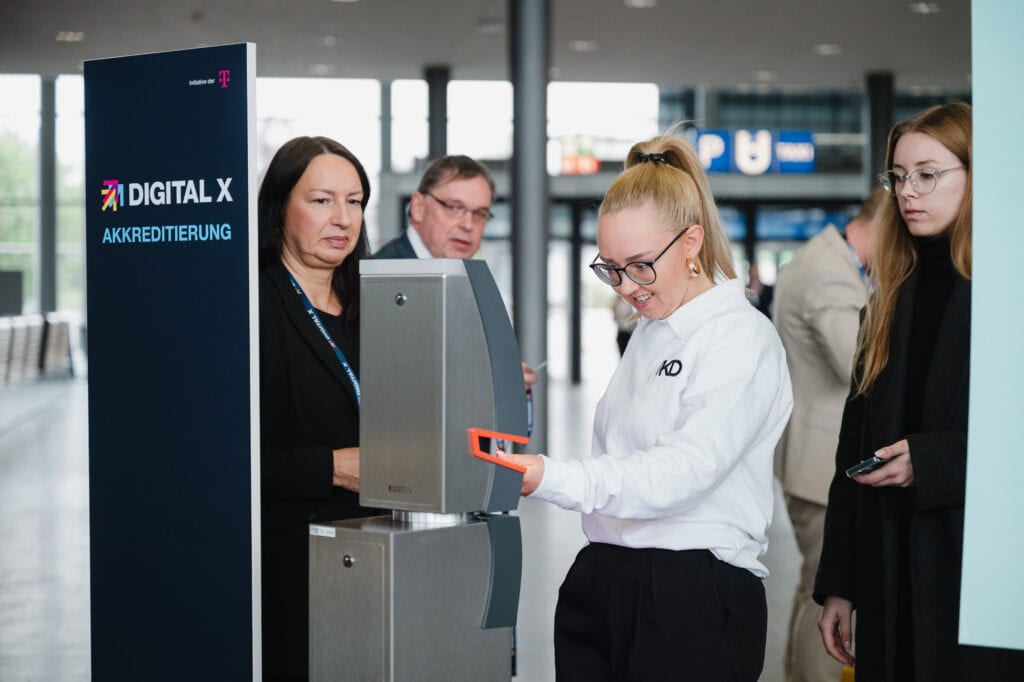 Digitalisierung im Norden: Das Digital X Regional Event 2025 6 Menschen bei Digital X Event in Köln, Fokus auf Digitalisierung und Innovation.