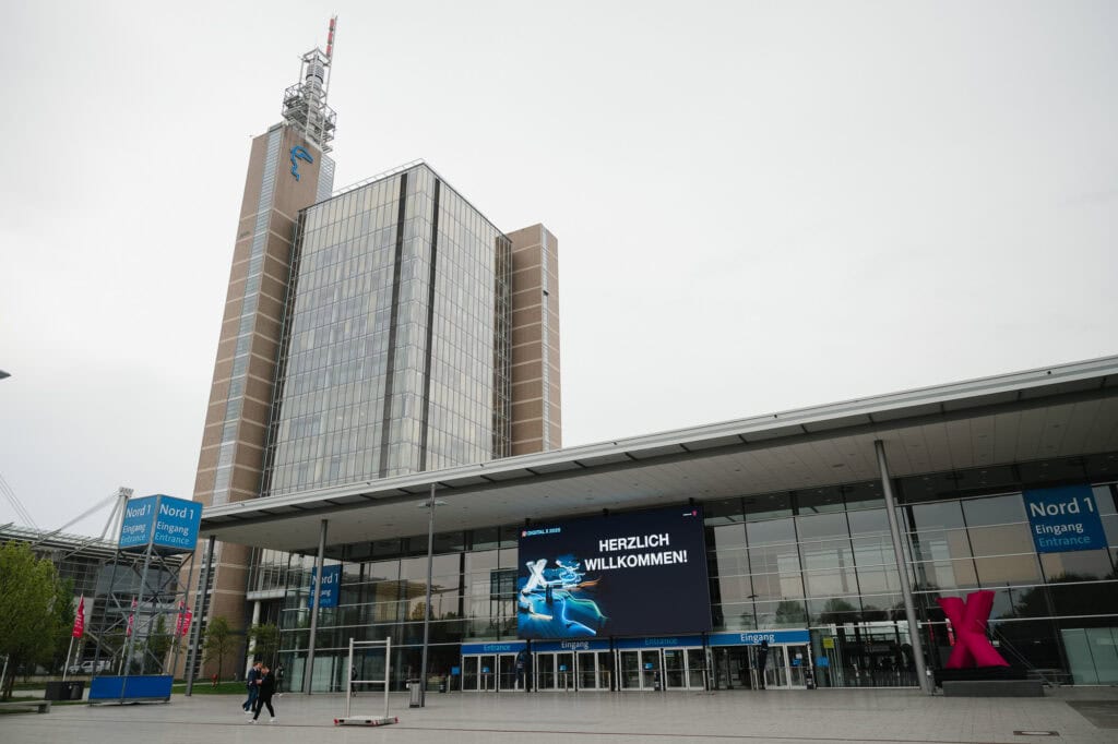 Digitalisierung im Norden: Das Digital X Regional Event 2025 5 Moderne Messehalle in Köln mit Digitalanzeige und Hochhaus im Hintergrund.